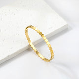 Hard bracelet with diamonds strung together with small gold-colored discs