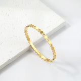 Hard bracelet with diamonds strung together with small gold-colored discs