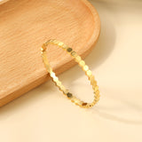 Hard bracelet with diamonds strung together with small gold-colored discs