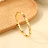 Hard bracelet with diamonds strung together with small gold-colored discs