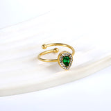 Teardrop green diamond with small white diamonds ending in an open round bead ring