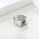 Exaggerated ring with green diamonds and engraved stamens.