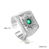 Exaggerated ring with green diamonds and engraved stamens.