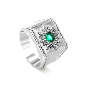 Exaggerated ring with green diamonds and engraved stamens.