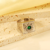 Exaggerated ring with green diamonds and engraved stamens.