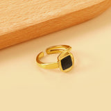 A minimalist ring with simple lines displayed with black drip polish