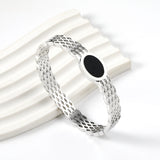 Woven mesh bracelet with black round oil drops.