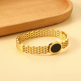 Woven mesh bracelet with black round oil drops.