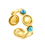 The ring consists of discs of various sizes and is set with 2 turquoise stones.