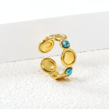 The ring consists of discs of various sizes and is set with 2 turquoise stones.