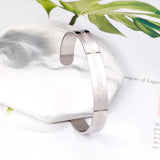 Extra wide hard open bangle in steel color with engraved surface