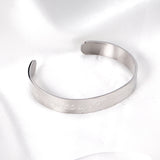 Extra wide hard open bangle in steel color with engraved surface