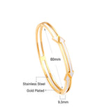 Gold colored hard bracelet with directional arrows with oil dripping in the center white color