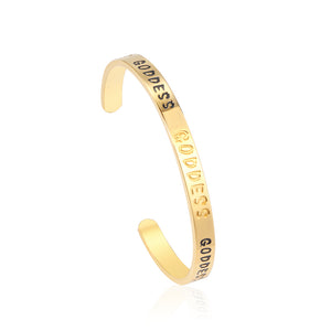 Gold colored hard bracelet with GODDESS printed on it