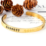 Gold colored hard bracelet with GODDESS printed on it