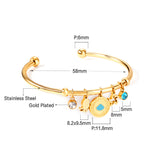 Gold bangle with two diamonds of different colors and a charm with a scallop on the door of the discus.