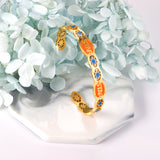 Hard bangle with many colors on the surface with drops of oil and shells in open gold color