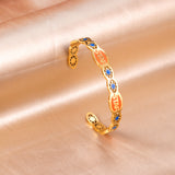 Hard bangle with many colors on the surface with drops of oil and shells in open gold color