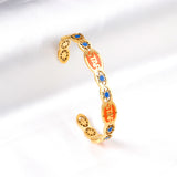 Hard bangle with many colors on the surface with drops of oil and shells in open gold color