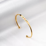 Hard bracelet with oil-drip pattern on gold-colored surface