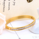 Gold-tone hard bracelet with a circle of diamonds in the center