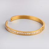 Gold-tone hard bracelet with a circle of diamonds in the center