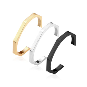 Three colors of black gold-tone steel with an angular face on an open-end rigid bracelet.